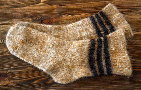 Knitted wool socks on a brown wooden background