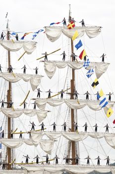 Few men standing up on the matt of sail boat, parade of Armada on the Seine, France