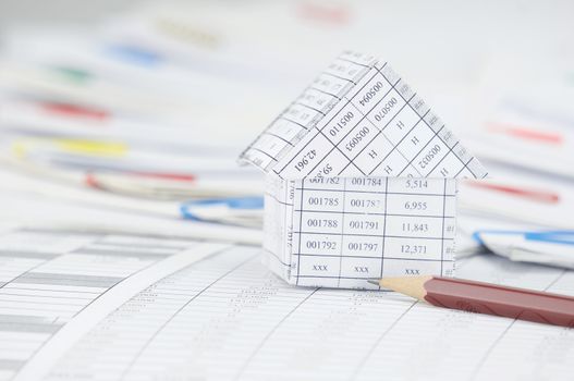 Close up house with brown pencil on finance account have step of paperwork with colorful paperclip place curve as background.