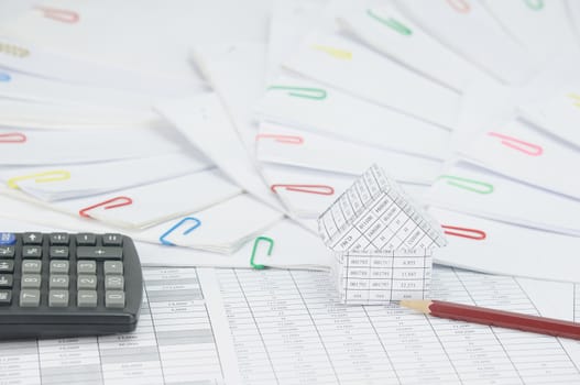 House with brown pencil and calculator on finance account have step of document with colorful paperclip place curve as background.