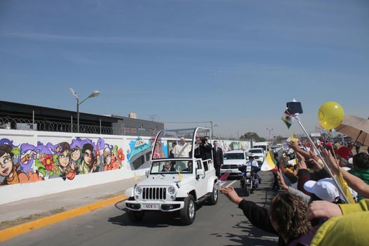 MEXICO, Ecatepec : Pope Francis waves at the crowd from the Popemobile before celebrating an open-air mass in Ecatepec, near Mexico City on February 14, 2016. Pope Francis urged Mexicans on Sunday to turn their country into a land of opportunity where there is no need to emigrate or mourn victims of the merchants of death. 