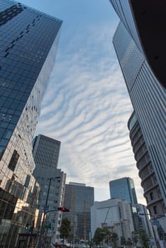 Osaka, Japan - November 4 : Upside view of office building in blue sky wave pattern