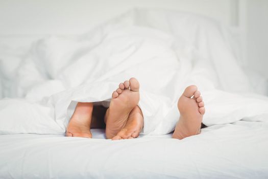 Feet sticking out from the blanket in bedroom