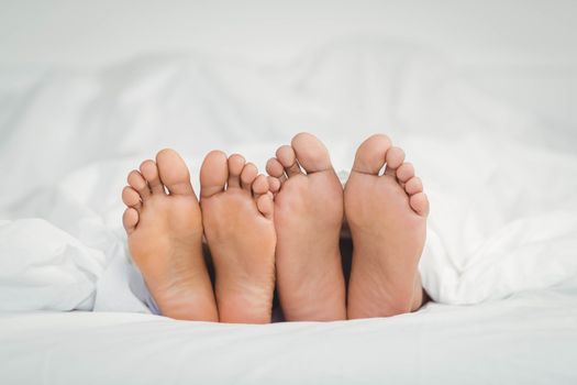 Feet sticking out from the blanket in bedroom