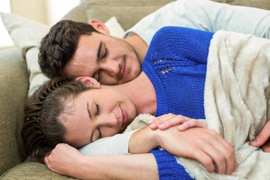 Romantic young couple cuddling on sofa in living room