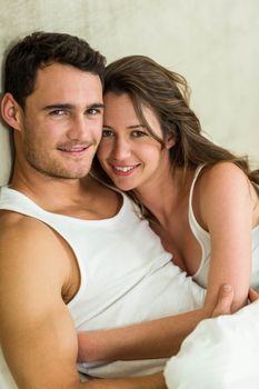 Portrait of romantic couple cuddling on bed in bedroom