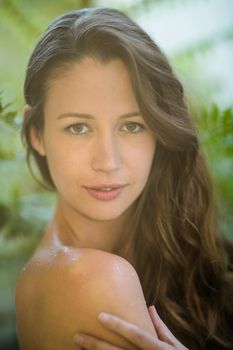 Beautiful woman standing outdoors against green plants