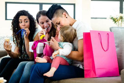 Three women sitting on a couch celebrating a babies first birthday