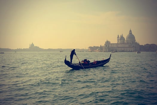 Traditional Gondola on Canal Grande with San Giorgio Maggiore church in the background in at sunset, San Marco, Venice, Italy (Filtered image processed vintage effect)