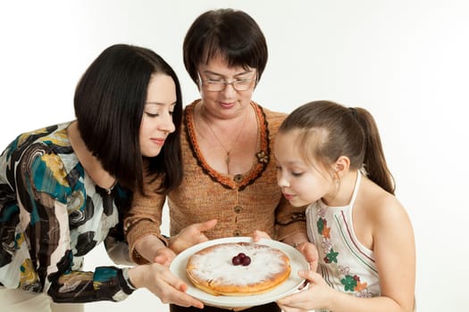 the grandmother holds the pie made for the daughter and the granddaughter