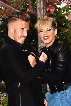 Fashionable young couple having fun in the street with trendy hairstyle. Urban fashion photography. Vertical image.