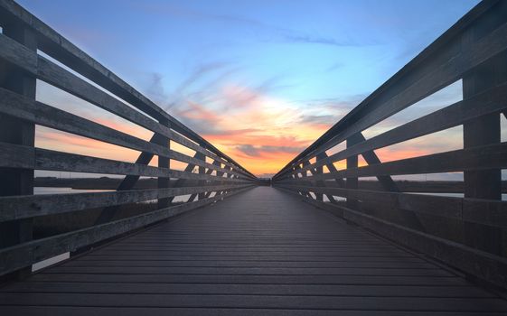 Wooden Boardwalk at sunset, to journey through Bolsa Chica Wetlands preserve in Huntington Beach, California, United States