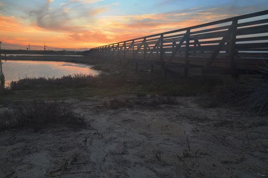 Wooden Boardwalk at sunset, to journey through Bolsa Chica Wetlands preserve in Huntington Beach, California, United States