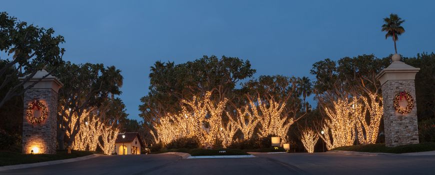 Crystal Cove, California — December 25, 2014: White Christmas holiday lights in Crystal Cove on the edge of Laguna Beach and Newport Beach on trees with a wreath on each pillar.