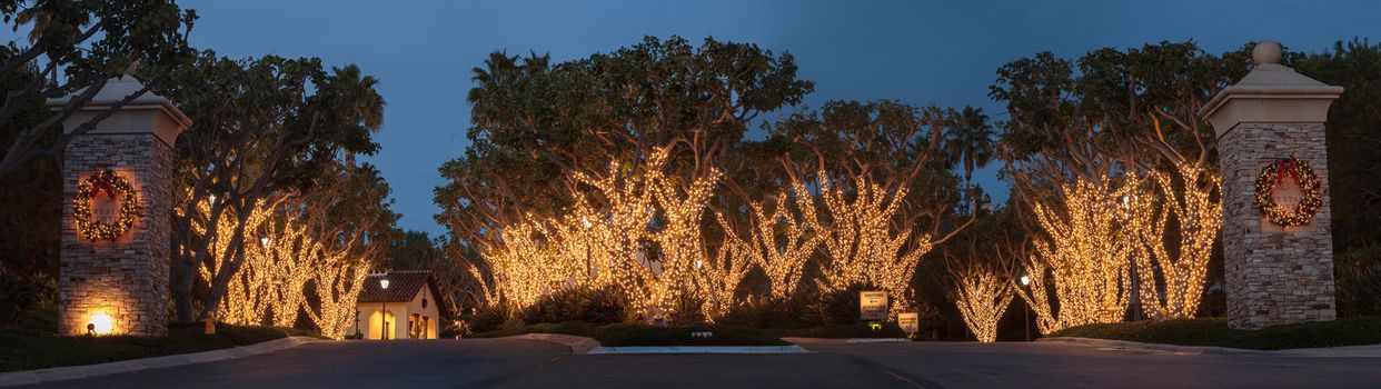 Crystal Cove, California — December 25, 2014: White Christmas holiday lights in Crystal Cove on the edge of Laguna Beach and Newport Beach on trees with a wreath on each pillar.