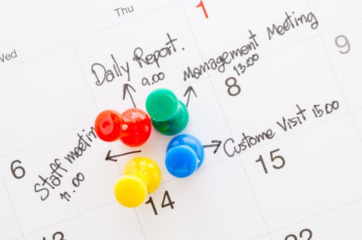 Pushpin on calendar with busy day overworked schedule.