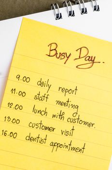 Busy day and plan in yellow stick note on calendar.