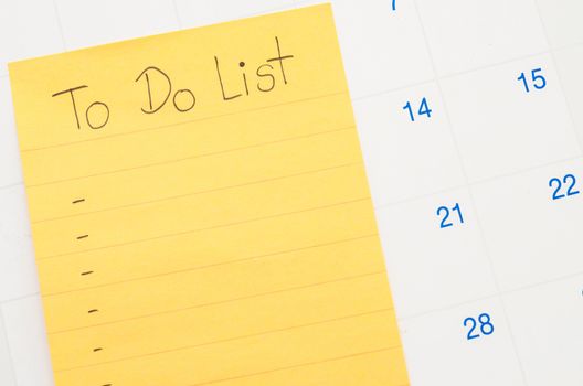 Handwritten To do list in stick note on calendar.