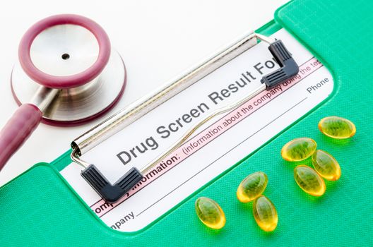 Drugs and drug screen result form in file with stethoscope on white background.