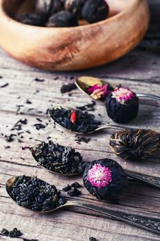 Few flavors of dry brewing loose leaf tea on wooden table