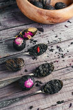 Few flavors of dry brewing loose leaf tea on wooden table