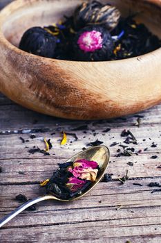 Few flavors of dry brewing loose leaf tea on wooden table