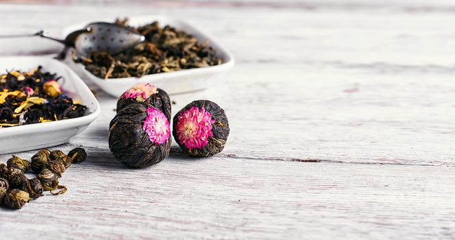 Few flavors of dry brewing loose leaf tea on wooden table