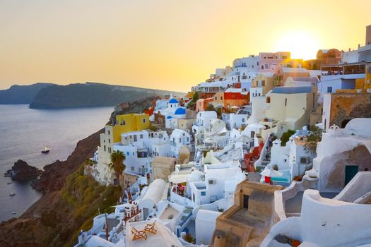 World famous traditional whitewashed chuches and houses of Oia village on Santorini island, Greece. Sunset.
