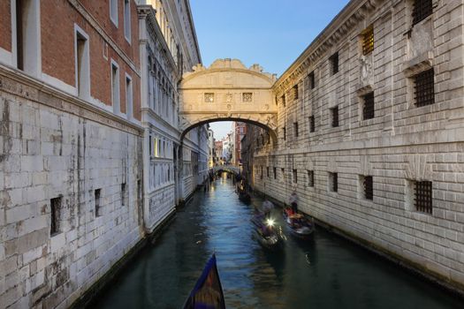 Gondolas passing under Bridge of Sighs, Ponte dei Sospiri. A legend says that lovers will be granted eternal love if they kiss on a gondola at sunset under the Bridge. Venice,Veneto, Italy, Europe. 