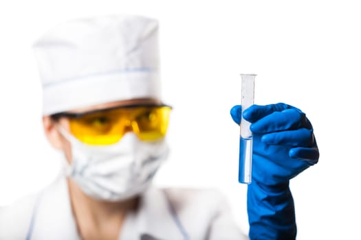 Woman chemist examines test tube on a blue background