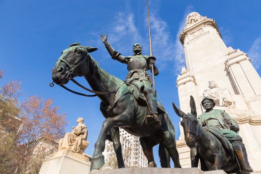 Stone statue of Miguel de Cervantes and bronze sculptures of Don Quixote and Sancho Panza on the Square of Spain (Plaza de Espana) in Madrid.