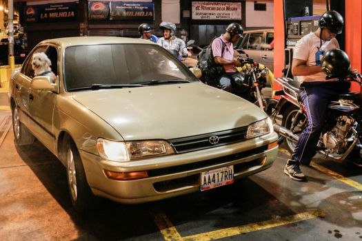 VENEZUELA, Caracas: Motorcyclists queue at a gas station in Caracas, on February 17, 2016. Venezuela's President Nicolas Maduro said Wednesday he would raise the price of gasoline for the first time in 20 years, as he faces growing pressure to ease an economic crisis. Maduro said in a televised address he would raise the pump price of premium gasoline from its current super-low level of $0.01 to the equivalent of $0.95 at the fixed official exchange rate, in a country where citizens are struggling with soaring inflation.