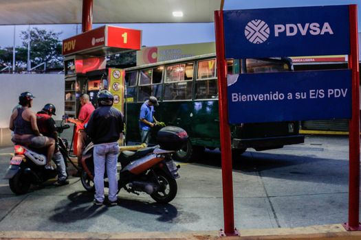 VENEZUELA, Caracas: Motorcyclists queue at a gas station in Caracas, on February 17, 2016. Venezuela's President Nicolas Maduro said Wednesday he would raise the price of gasoline for the first time in 20 years, as he faces growing pressure to ease an economic crisis. Maduro said in a televised address he would raise the pump price of premium gasoline from its current super-low level of $0.01 to the equivalent of $0.95 at the fixed official exchange rate, in a country where citizens are struggling with soaring inflation.