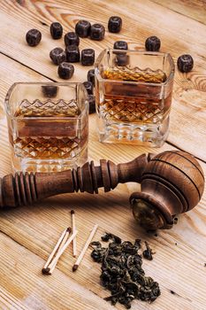 Smoking pipe in a retro style,dark chocolate and glasses of whiskey on wooden background