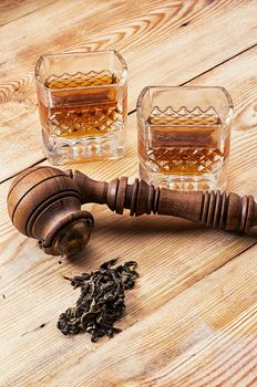 Smoking pipe in a retro style,dark chocolate and glasses of whiskey on wooden background