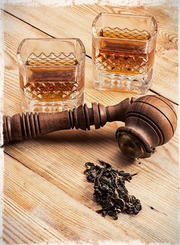 Smoking pipe in a retro style,dark chocolate and glasses of whiskey on wooden background