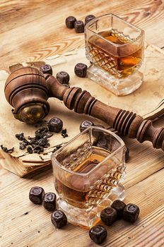 Smoking pipe in a retro style,dark chocolate and glasses of whiskey on wooden background