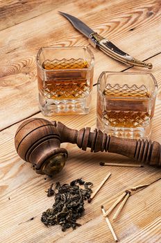 Smoking pipe in a retro style,dark chocolate and glasses of whiskey on wooden background