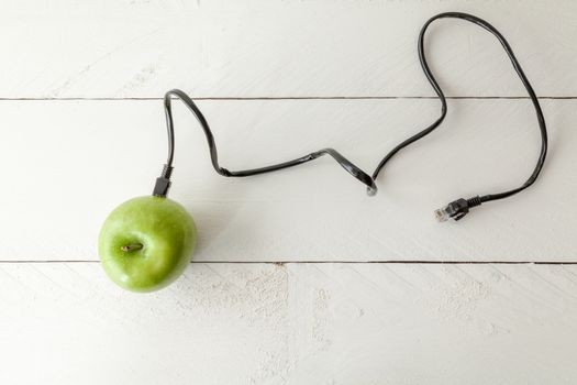 The picture shows an apple connected to an ethernet cable conceptualizing the internet of things and wearables