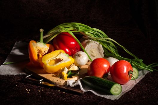 Fresh vegetables for cooking on a black background. Filmed from the light brush.