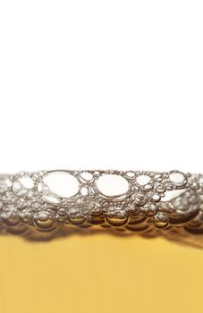 Vertical close up of beer froth isolated on white background