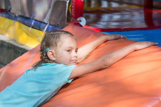 Six-year girl lies on a soft mat in front of the street childrens room