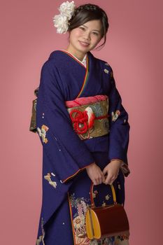 A portrait of a beautiful young Japanese girl in a blue kimono for her coming of age ceremony on her 20th birthday.