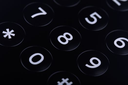 Horizontal top view close up of the keypad of a telephone with numbers showing