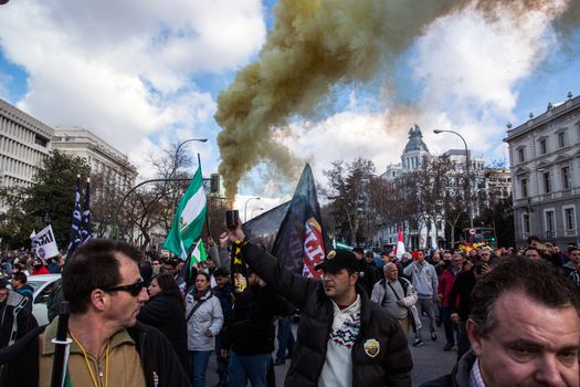 SPAIN, Madrid: A man holds a smoke bomb as thousands of taxi drivers demonstrate against deregulation and ride-hailing companies such as Uber, in Madrid, on February 18, 2016.