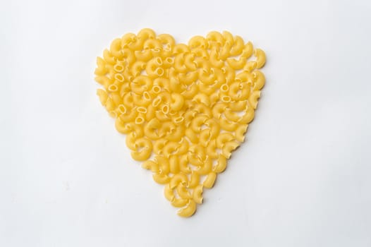 Pasta macaroni isolated on white background in a heart shape