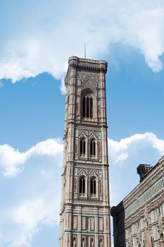 View of belfry tower of Florence Duomo, Santa Maria Del Fiore, on cloudy blue sky background.