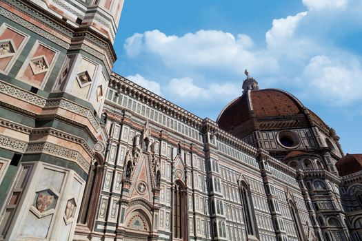Side view of famous historical Florence Duomo, Santa Maria Del Fiore, on cloudy blue sky background.