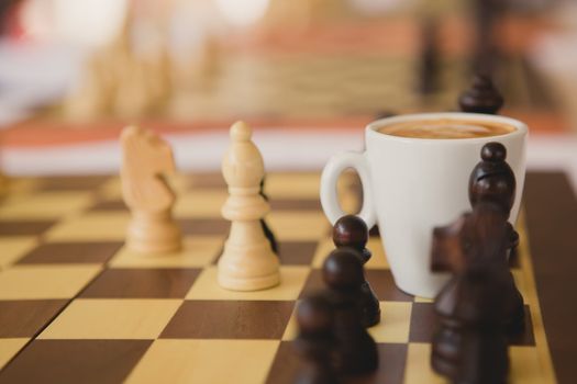 Leisure relax time or business strategy concept. Part of chess table with coffee cup hot drink 