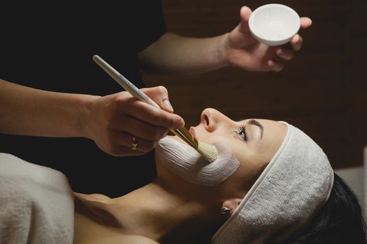 Close-up of young woman with facial mask in spa